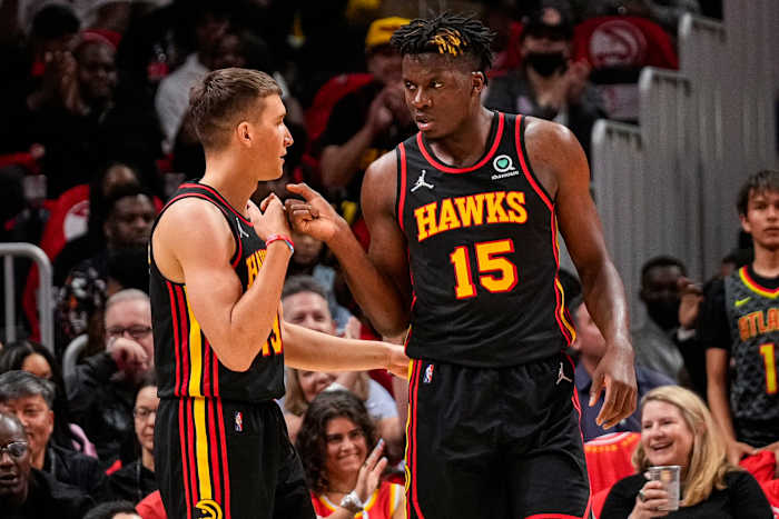 Apr 13, 2022; Atlanta, Georgia, USA; Atlanta Hawks center Clint Capela (15) reacts with guard Bogdan Bogdanovic (13) after scoring a basket against the Charlotte Hornets during the first half at State Farm Arena.